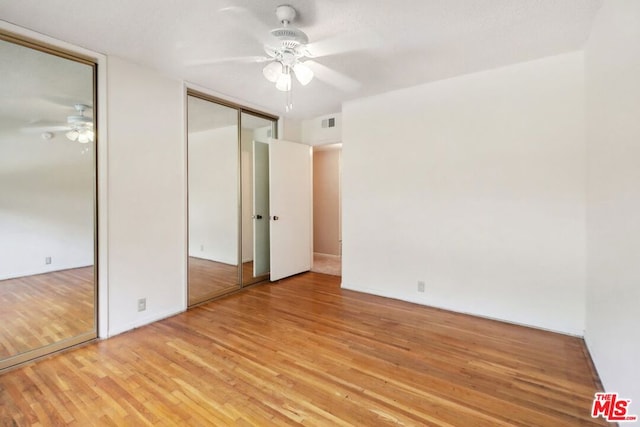 unfurnished bedroom with a closet, light hardwood / wood-style floors, and ceiling fan