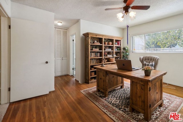 office with a textured ceiling, ceiling fan, and dark wood-type flooring