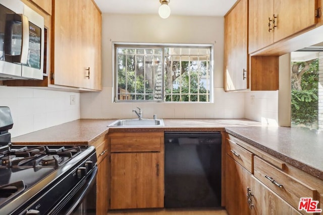 kitchen with decorative backsplash, sink, and black appliances