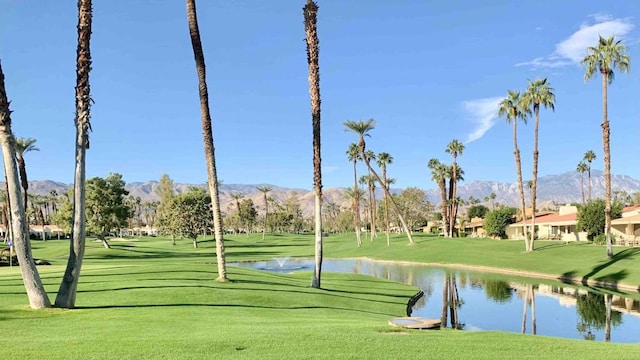 view of property's community featuring a yard and a water and mountain view