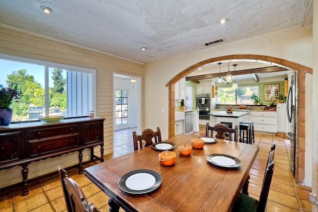 tiled dining room featuring ceiling fan and a textured ceiling