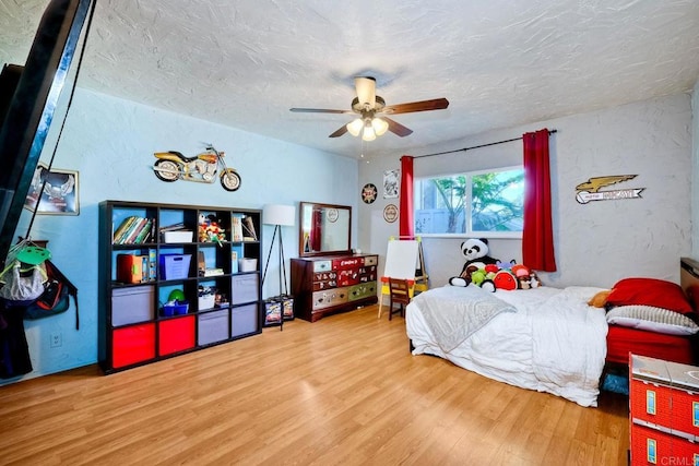 bedroom featuring hardwood / wood-style floors, ceiling fan, and a textured ceiling