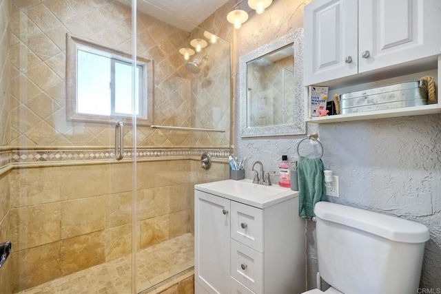 bathroom with vanity, toilet, and a shower with shower door