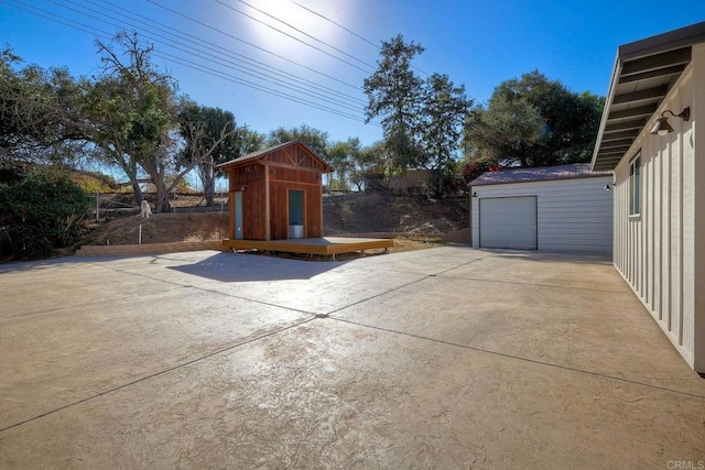 view of patio featuring a wooden deck, a garage, and a storage unit