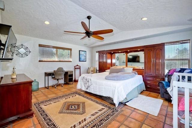 tiled bedroom featuring a textured ceiling, ceiling fan, and vaulted ceiling