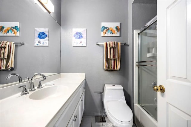 full bathroom with tile patterned flooring, vanity, toilet, and bath / shower combo with glass door