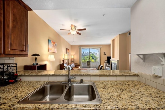 kitchen featuring ceiling fan, kitchen peninsula, and sink