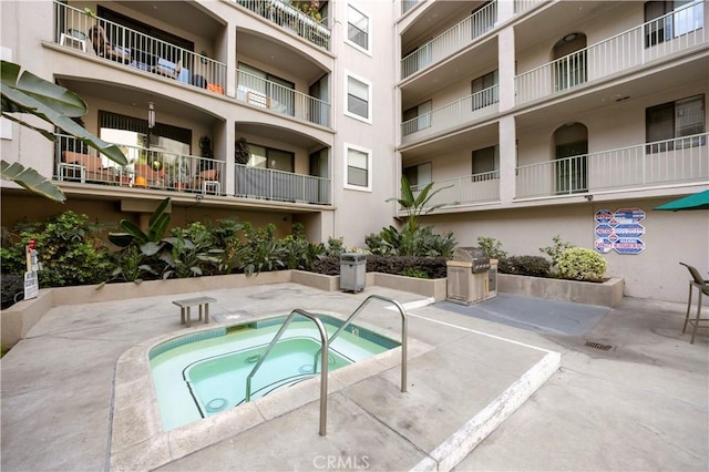 view of swimming pool featuring a patio area and a hot tub