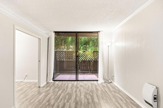 unfurnished room featuring expansive windows, crown molding, a textured ceiling, and light wood-type flooring