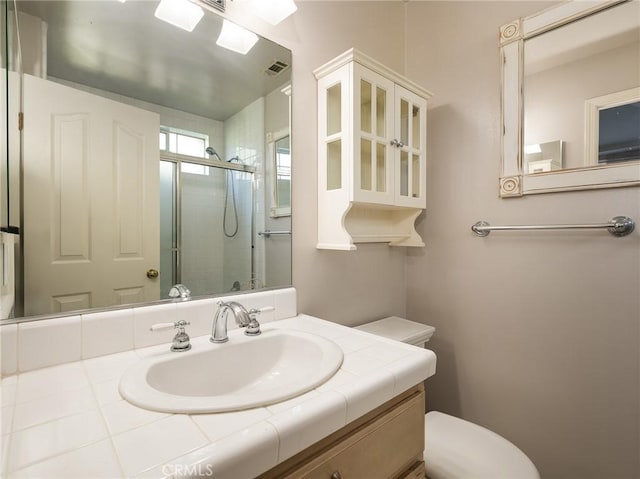 bathroom with vanity and a shower with door