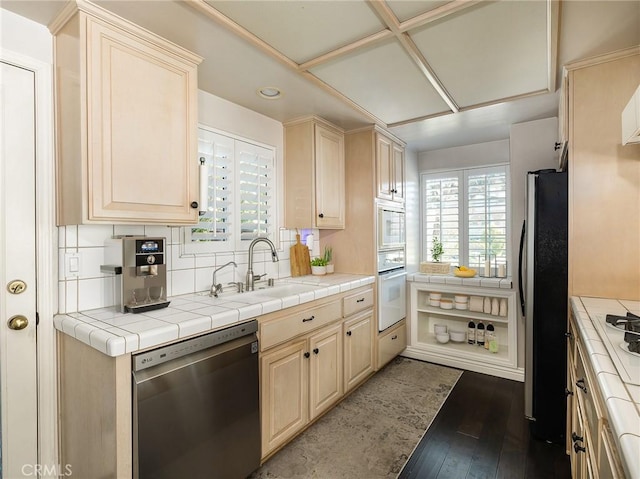 kitchen featuring tile counters, dark hardwood / wood-style flooring, sink, and appliances with stainless steel finishes