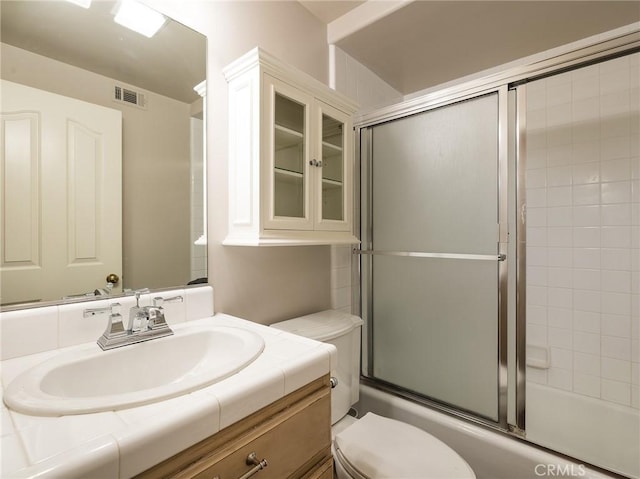 full bathroom featuring vanity, toilet, and enclosed tub / shower combo