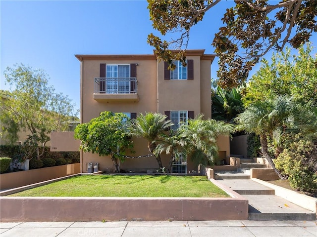 view of front of home featuring a balcony and a front lawn