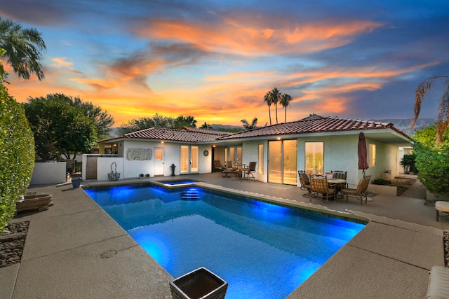 pool at dusk with a patio