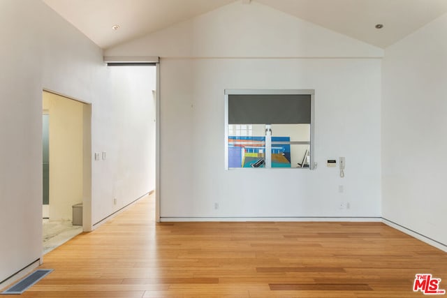 unfurnished room with high vaulted ceiling and light wood-type flooring