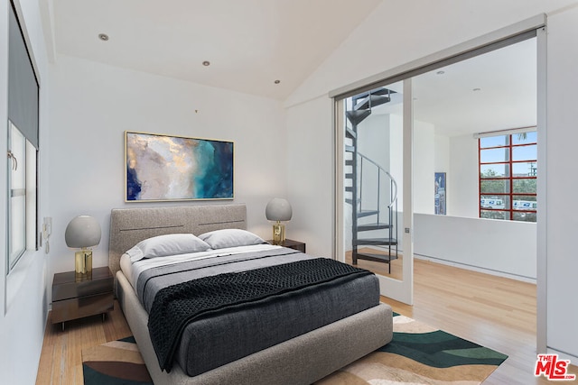 bedroom featuring hardwood / wood-style floors and vaulted ceiling