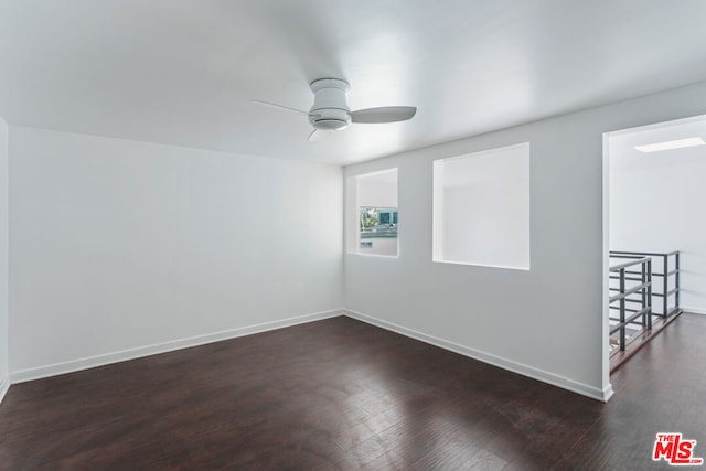 empty room featuring dark hardwood / wood-style flooring and ceiling fan