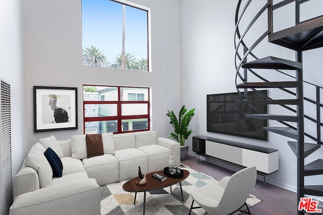 living room with a towering ceiling and wood-type flooring