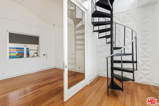 stairway featuring french doors, wood-type flooring, and vaulted ceiling