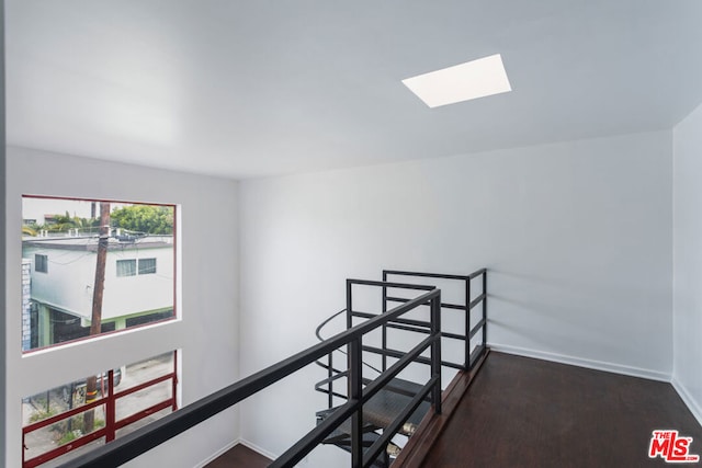 hallway with a skylight and dark hardwood / wood-style floors