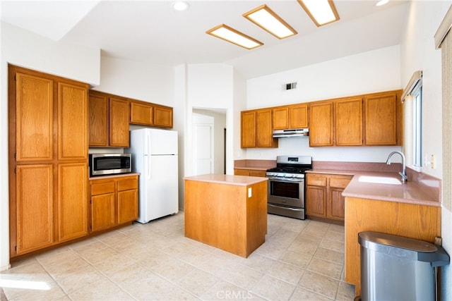 kitchen with sink, stainless steel appliances, light tile patterned floors, high vaulted ceiling, and a kitchen island