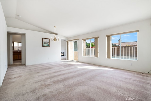 spare room featuring light colored carpet, an inviting chandelier, lofted ceiling, and sink