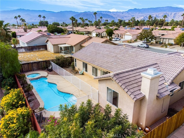 view of pool with a mountain view and an in ground hot tub