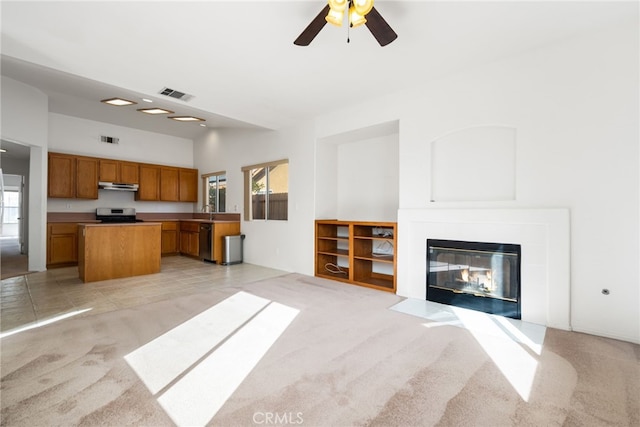 unfurnished living room with light carpet, sink, and ceiling fan