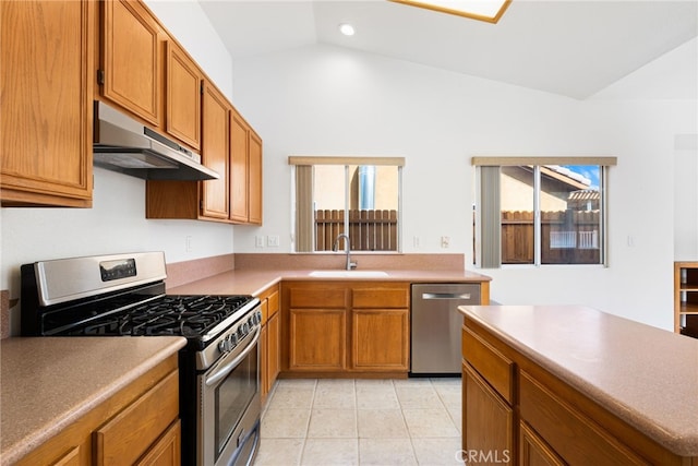 kitchen featuring appliances with stainless steel finishes, vaulted ceiling, a healthy amount of sunlight, and sink