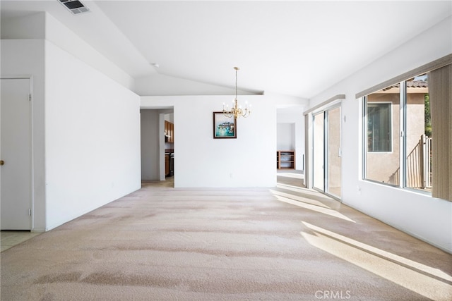 empty room featuring light carpet, vaulted ceiling, and an inviting chandelier