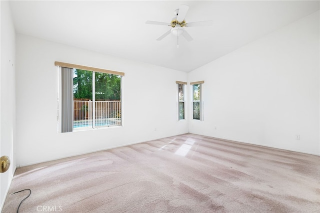 unfurnished room with ceiling fan, light carpet, a wealth of natural light, and vaulted ceiling