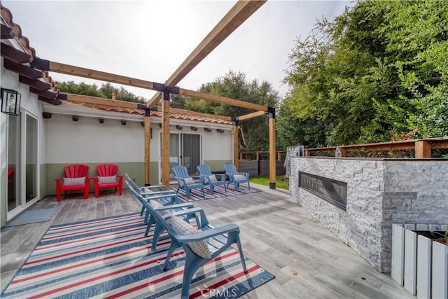 view of patio / terrace with an outdoor stone fireplace and a deck