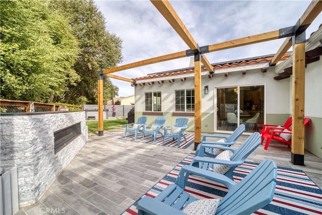 view of patio with an outdoor stone fireplace and a deck