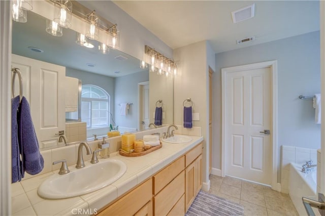 bathroom featuring vanity, a tub to relax in, and tile patterned floors