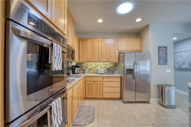 kitchen featuring appliances with stainless steel finishes, backsplash, light brown cabinetry, and light tile patterned flooring