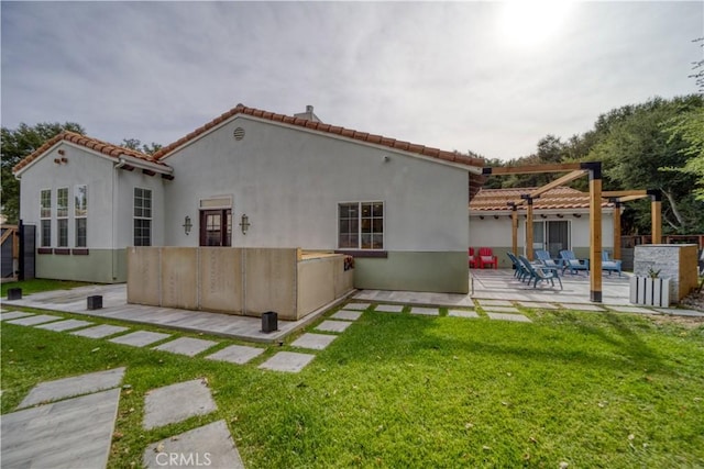 back of house with a patio and a lawn