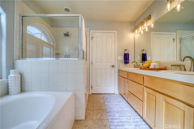 bathroom with vanity, tile patterned flooring, and plus walk in shower