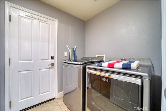 laundry room with washing machine and dryer and light tile patterned floors