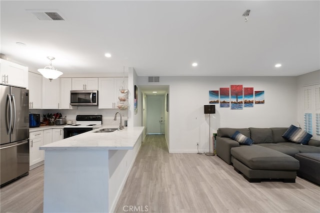 kitchen featuring kitchen peninsula, stainless steel appliances, sink, white cabinets, and light hardwood / wood-style floors