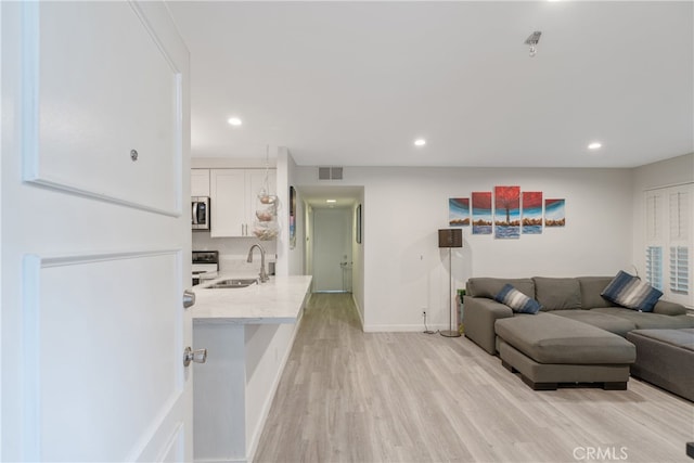 living room with sink and light hardwood / wood-style flooring