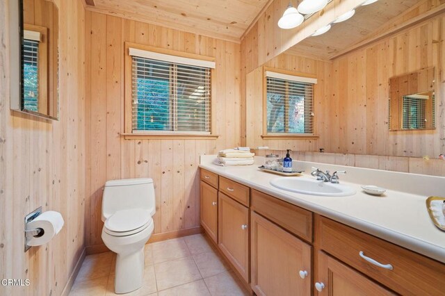 bathroom featuring tile patterned flooring, toilet, wooden walls, vanity, and wood ceiling