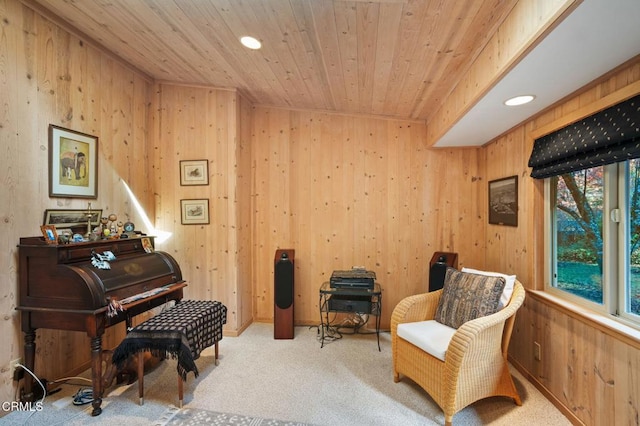 living area with light carpet, wooden ceiling, and wood walls