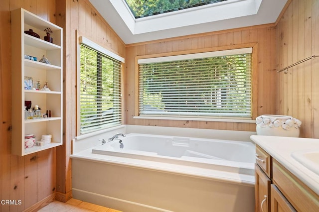 full bathroom with vaulted ceiling with skylight, wood walls, vanity, and a bath