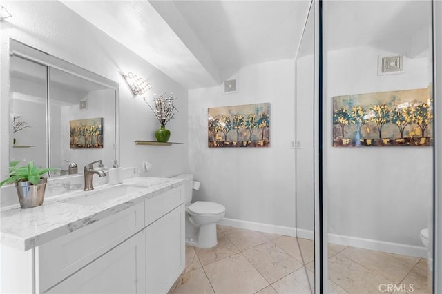 bathroom featuring vanity, vaulted ceiling, and toilet