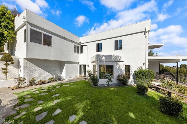 back of property featuring a lawn and a carport