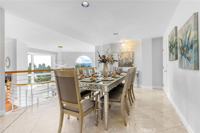 dining area with light tile patterned floors and vaulted ceiling