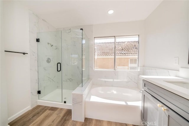 bathroom featuring wood-type flooring, vanity, and separate shower and tub