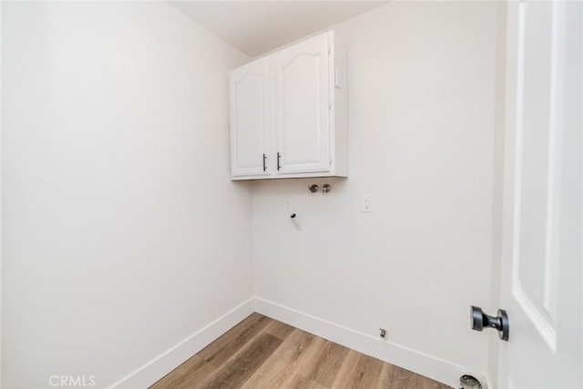 laundry area featuring washer hookup, cabinets, and light wood-type flooring