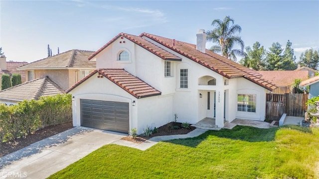 mediterranean / spanish home featuring a garage and a front lawn