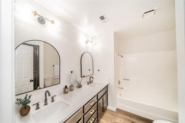 full bathroom featuring vanity, wood-type flooring, tub / shower combination, and toilet